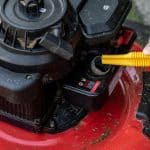 Closeup,Of,Man,Filling,Up,Red,Lawnmower,With,Gasoline,From